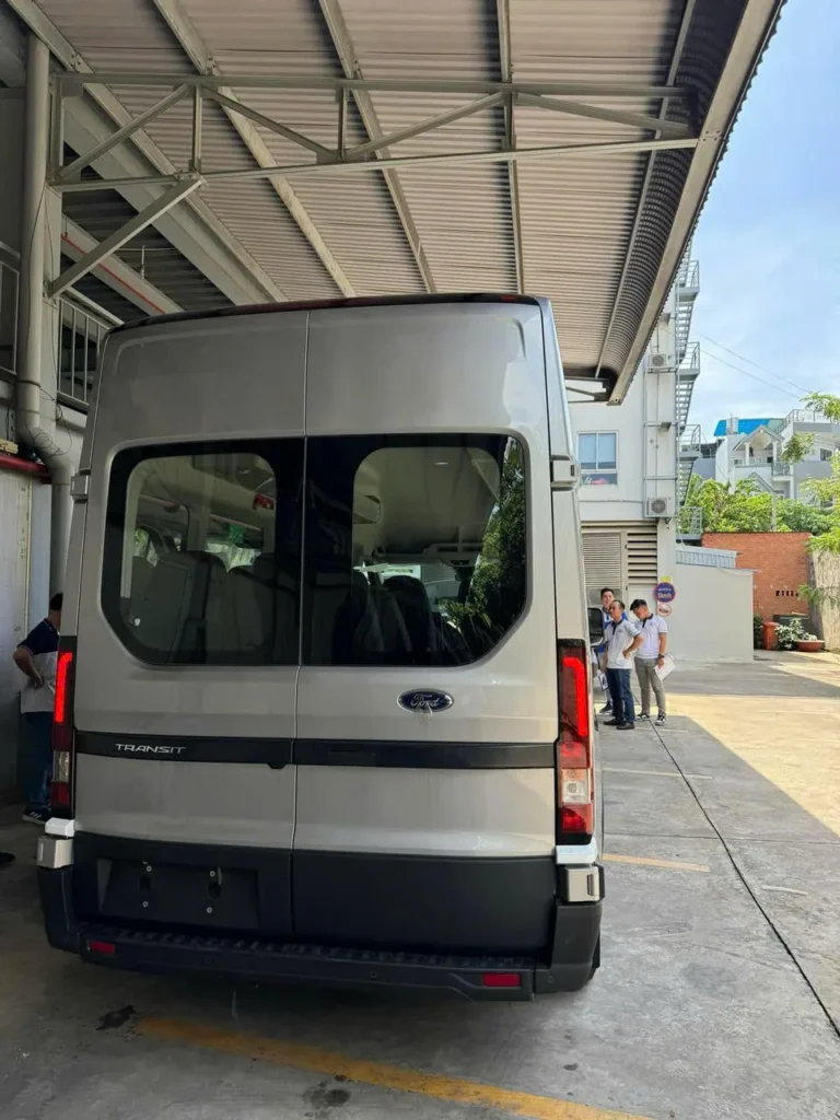 Phía sau Ford Transit 18 chỗ đỗ dưới mái che